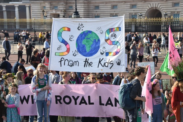 rewild royal land banner and SOS from the kids banner outside Buckingham Palace